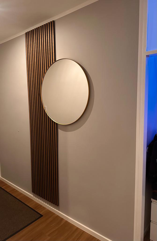Ein runder Spiegel vor einer Akustikpaneele